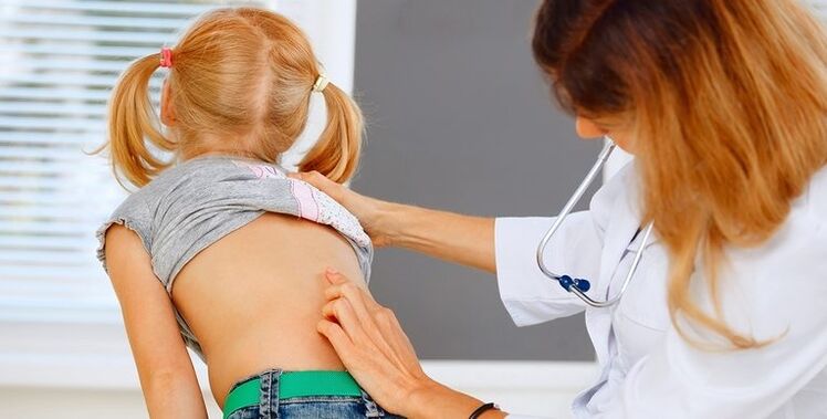 doktor pregleda djetetova leđa zbog bolova u donjem dijelu leđa